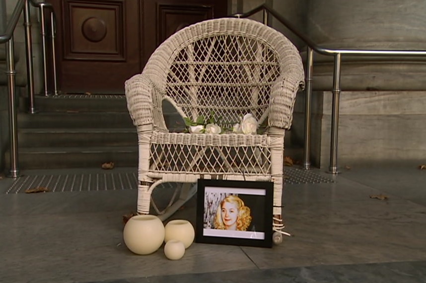 A cane chair with candles, a photo of Ann Marie and flowers on the steps of the SA parliament building