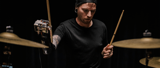 Jason Barnes plays the drums with his AI-powered robotic prosthesis